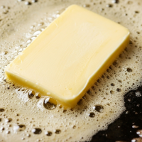 Pat of butter bubbling in frying pan